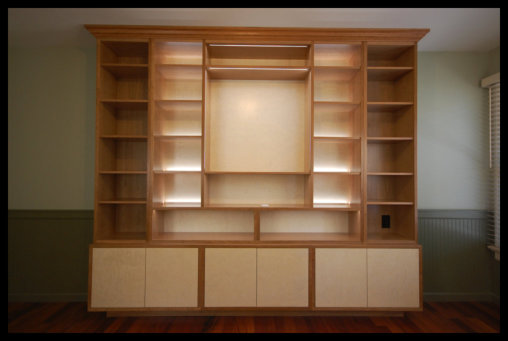 Cherry built-in with inset quilted curly maple doors, hidden hinges, and 4-zone integrated LED lighting; no particle board.