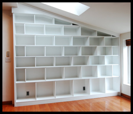 14ft wide staggered custom bookcases in white painted Hard Rock Maple, designed for art book collections.
