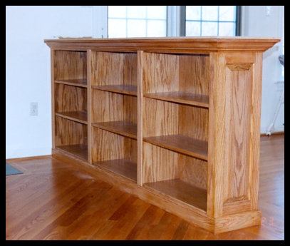 Custom 8-foot wide red oak built-in with fixed shelving and raised-panel side detailing, standing 38 inches tall.