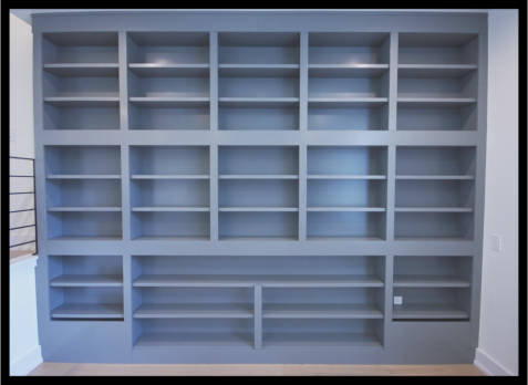13ft wide custom Maple built-in bookcases, 10ft high with light gray finish and integrated blanket storage.